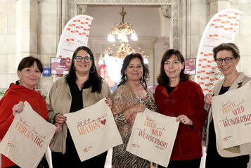 Die fünf Frauen stehen im Wiener Rathaus und halten jeweils eine Stofftasche mit Sprüchen zum Frauentag in Händen.