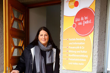 Kathrin Gaál steht in der Tür eines Wohnpartner Grätzl-Zentrums. Sie hat braune lange Haare und trägt herbstliche Kleidung.