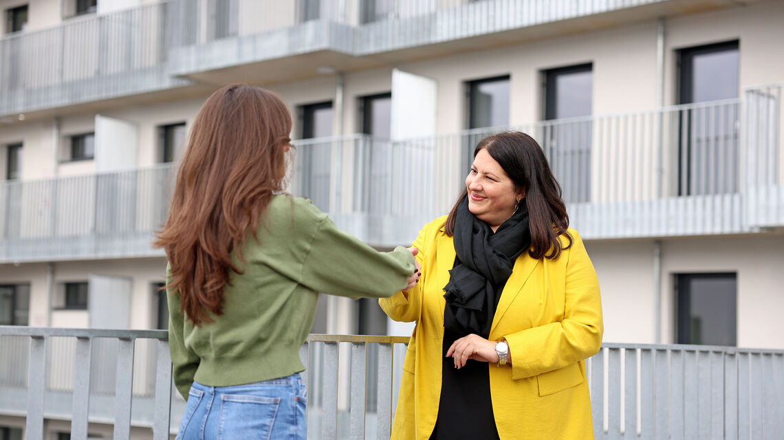 Kathrin Gaál steht einer langhaarigen jungen Frau gegenüber. Die Vizebürgermeisterin schüttelt der Frau die Hand.