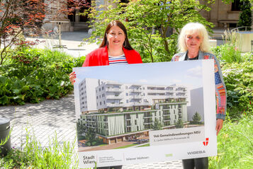 Vizebürgermeisterin Kathrin Gaal hält gemeinsam mit der Bezirksvorsteher-Stellvertreterin des dritten Bezirks, Susanne Wessely eine Tafel, die eine Visualisierung des Gemeindebau NEU im Village im Dritten zeigt.