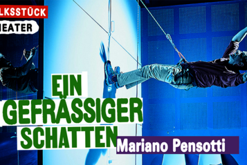 Das Bild zeigt das Plakat der Stückes "Ein Gefräßiger Schatten" der Wiener Festwochen - Volksstück Theater. Der Titel sowie der Name des Regisseurs Marina Pensotti sine darauf zu lesen. Das Bild selbst zeigt einen Szenenausschnitt bei dem die beiden Schauspieler mit einem Seil jeweils auf einer Seite einer Wand hängen und sich mit den Beinen von dieser wegstemmen. 
